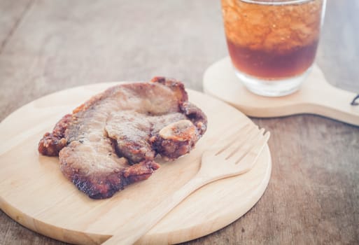 Pork steak on wooden plate, stock photo