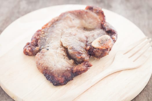 Pork steak on wooden plate, stock photo