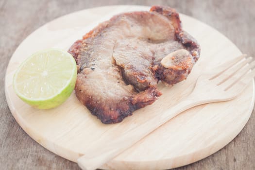 Pork steak on wooden plate, stock photo