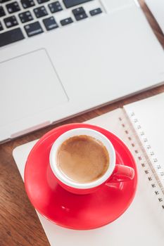 Red coffee cup with notepad and laptop, stock photo