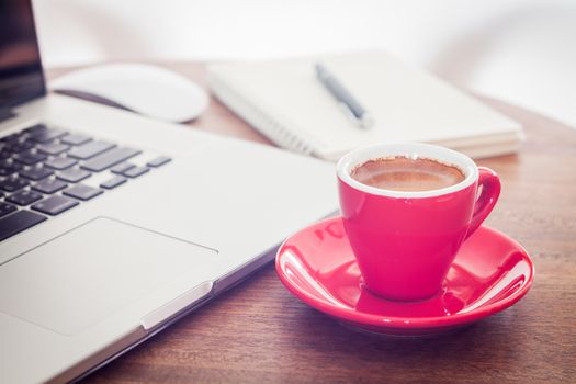 Red coffee cup with notepad and laptop, stock photo