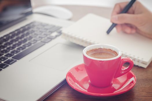 Red coffee cup with notepad and laptop, stock photo