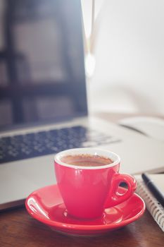 Red coffee cup with notepad and laptop, stock photo