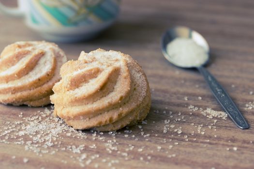 sugar biscuit with cup on wooden table