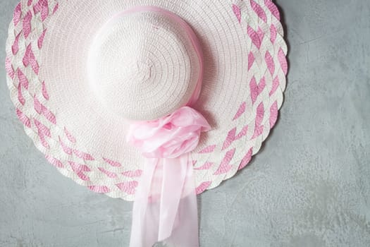 Pink hat with ribbon on grey background, stock photo