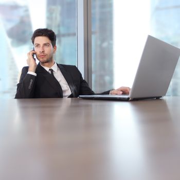 Busy businessman in office working on his laptop