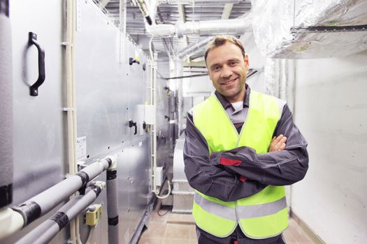 Worker in electrical switchgear room of CNC plant