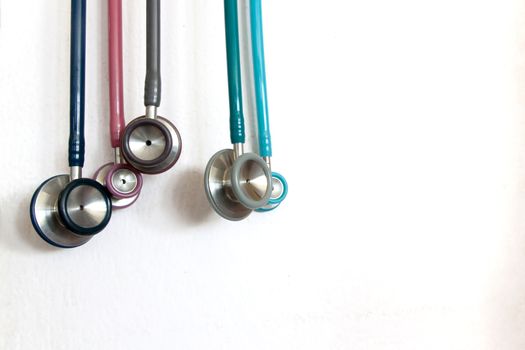 stethoscope many color a small side for check children on white wall.