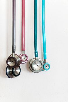 stethoscope many color a small side for check children on white wall.