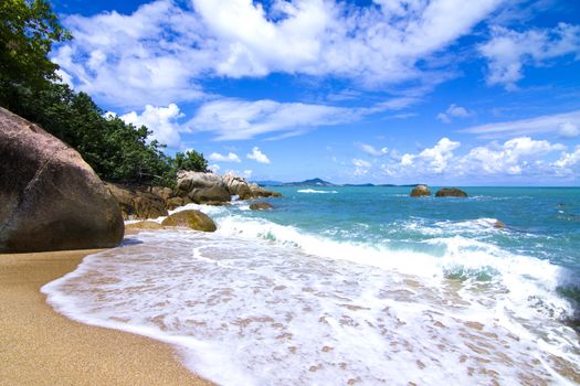 There are beautiful views of the beach, the waves and the rocks.