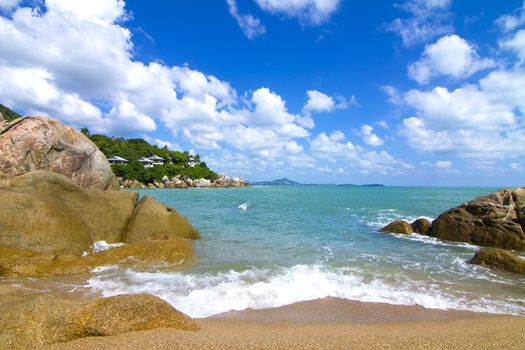 There are beautiful views of the beach, the waves and the rocks.