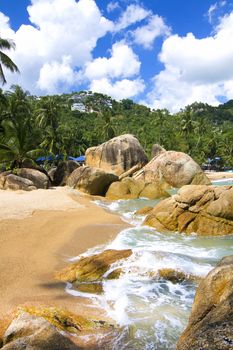 There are beautiful views of the beach, the waves and the rocks.