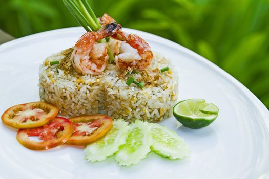 Shrimp Fried Rice on the white plate is placed in the midst of nature.