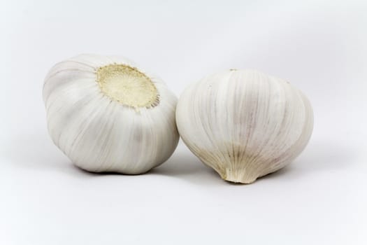 Fresh garlic bulbs close-up lie on a light background