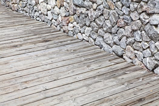 Wooden floor and stone walls background,The rock walls and wooden floor.