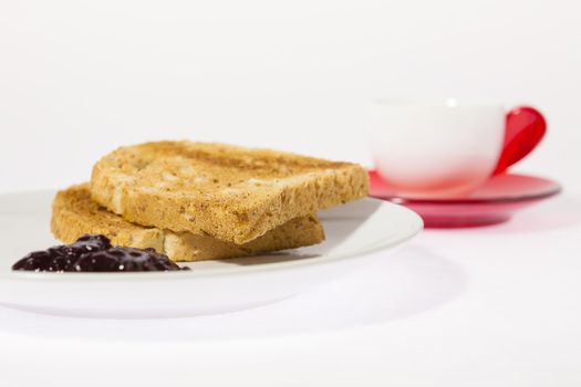 Cup of espresso coffee and some bread with jam