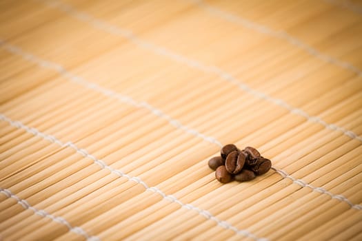 Some coffee-beans on a bamboo placemat