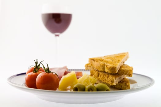 A tasty mediterranean plate match to a red wine glass