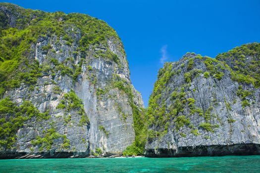 Thailand beach seascape with ring of steep limestone hills and traditional bright longtail boats parking, Maya Bay, Ko Phi Phi Lee island, Phi Phi archipelago, part of Krabi Province, Andaman Sea