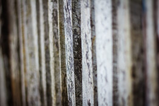 Detail view along an old  picket wooden fence with selective focus