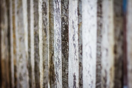 Detail view along an old  picket wooden fence with selective focus