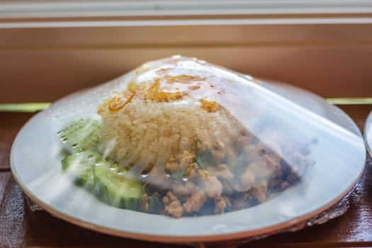 Rice topped with stir-fried chicken, basil and fried egg, fried stir basil with minced chicken on white background