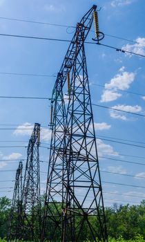 v supports of high-voltage power lines against the blue sky