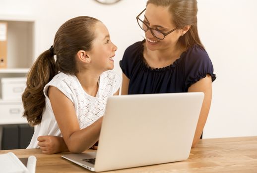 Mother and daugther at home doing homework together