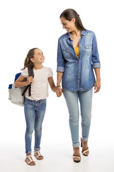 Mother and her little daughter walking together going to the school