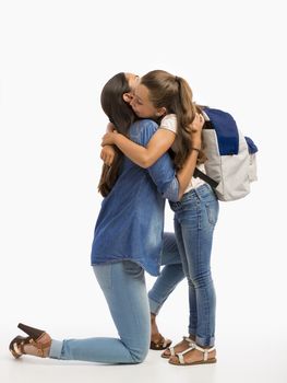 Mother hugging her little daughter and saying good-bye on the first day of school