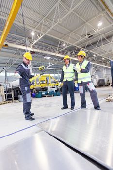 Workers near aluminium billet at CNC machine shop