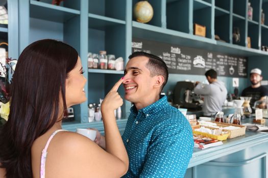 Cheerful loving couple having fun in cafeteria