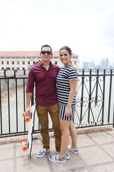 Couple loving each other, man holding skateboard