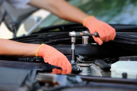 Hands of car mechanic in auto repair service