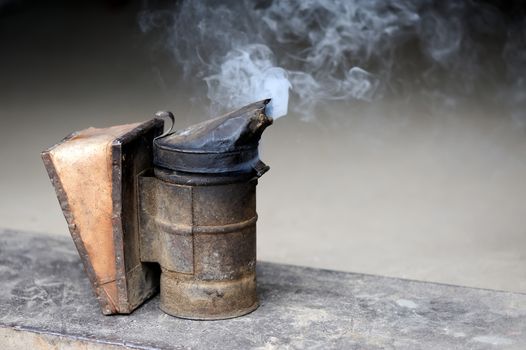 Closeup of bee smoker on crate at farm