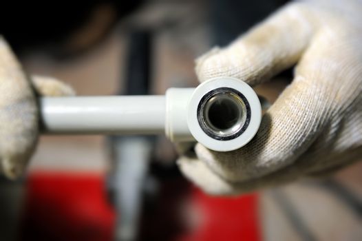 Plastic plumbing pipe in worker hand