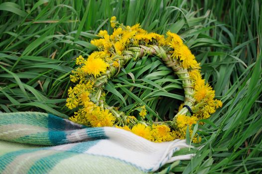 Flower wreath with yellow blooming flowers in grass