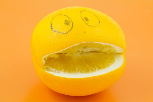 Funny orange with a face man lies on an orange background