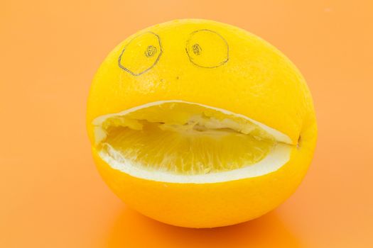 Funny orange with a face man lies on an orange background