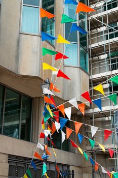 Gaily coloured flags or bunting attached to street lamp post in Brighton.