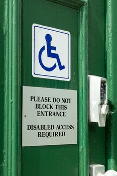 Door sign informing of requirement to leave access for disabled users.