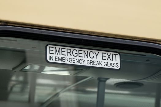 Bus window Emergency Exit sign advising breaking glass.