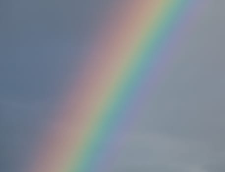 Detail of rainbow against dark cloud, showing full colour spectrum.