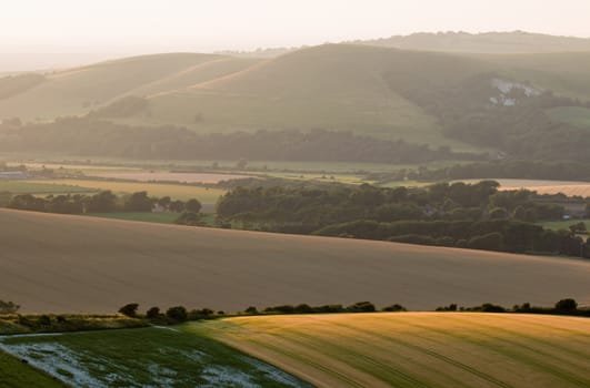 View from near Firle Beacon looking north west across to Mount Caburn and South Downs at sunset.