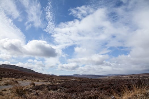 Cloudy and blue sky and landscape near Lochindorb in the Scottish Highlands, during March.