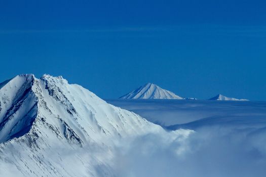 Kamchatka mountain tops in clouds. Aerial view