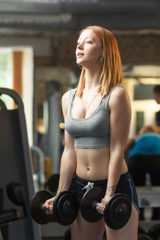 Concept: sport, healthy lifestyle. Young strong girl do exercises with dumbbells