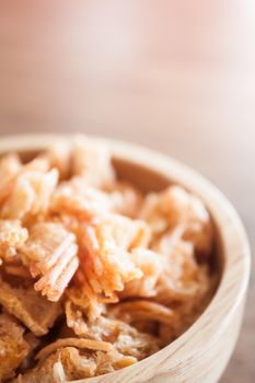 Fried shrimp chins snack in wooden bowl, stock photo