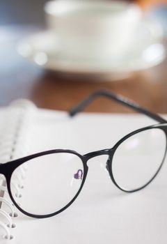 Eyeglasses on opened spiral notebook , stock photo