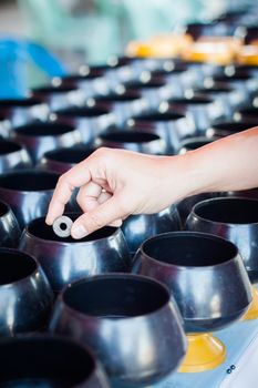 Woman put a coin in the alms-bowl for merit, stock photo